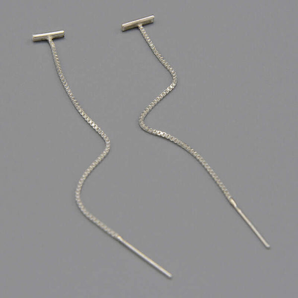 Pair of silver threader earrings, small bar with fine gold chain ending in bar, shown at angle.