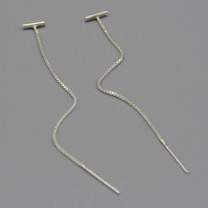 Pair of silver threader earrings, small bar with fine gold chain ending in bar, shown at angle.