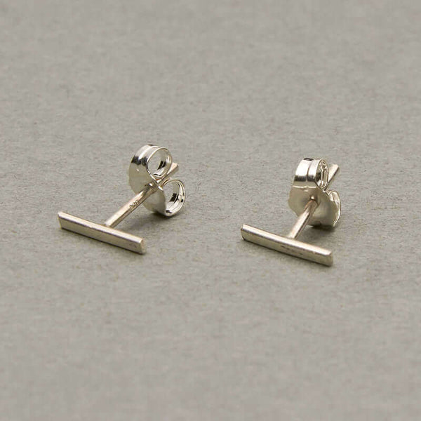 Pair of silver bar earrings on earpost.