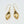 Pair of gold earrings, with curved simple leaf design, shown askew.