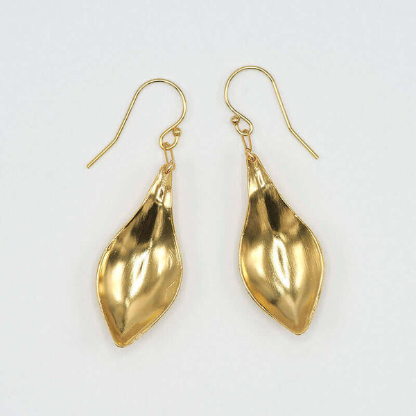 Pair of gold earrings, with curved simple leaf design, shown askew.