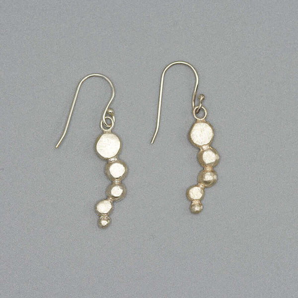 Pair of silver earrings with flattened beads of descending size.