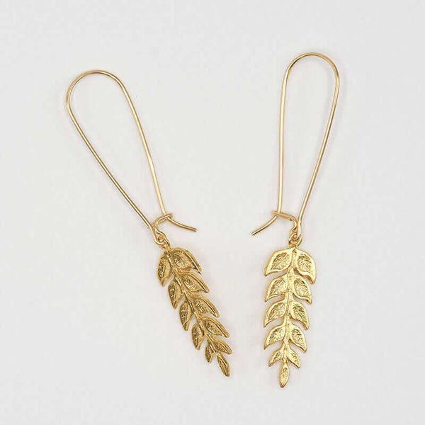 Pair of gold fern leaf shaped earrings on long earwire.