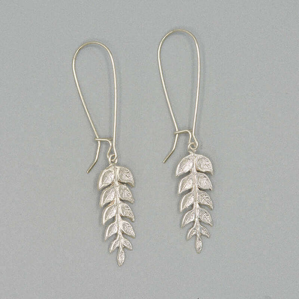 Pair of silver fern leaf shaped earrings on long earwire.