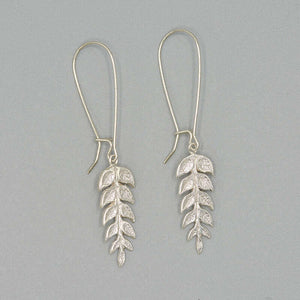 Pair of silver fern leaf shaped earrings on long earwire.