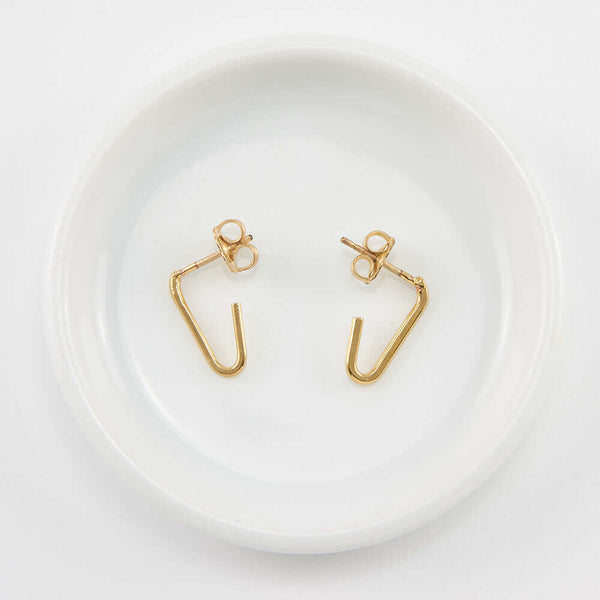 Pair of gold bent angle earrings on posts.
