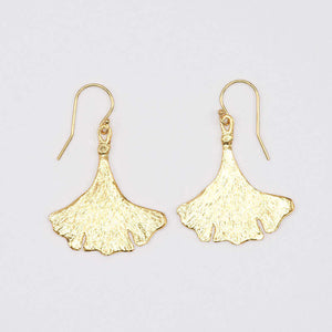 Pair of gold earrings shaped like ginko leaves.