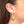 Load image into Gallery viewer, Close up side view of woman wearing pair of gold geometric native motif hoop earrings.
