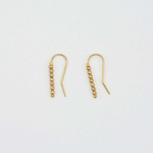Pair of small gold wire earrings with gold beads.