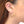 Load image into Gallery viewer, Close up side view of woman wearing pair of cast brushed gold hoop style earrings.
