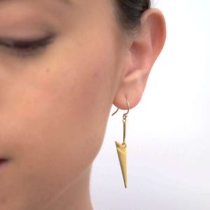 Close up front view of woman wearing pair of gold chevron shaped earrings on earwire.