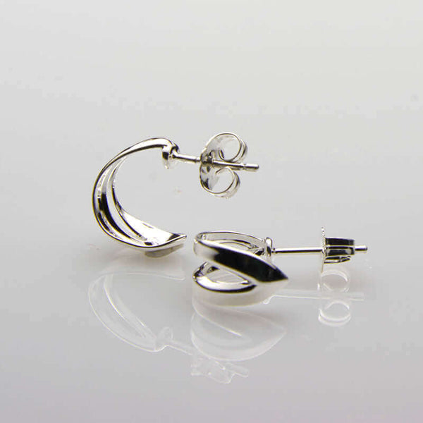 Pair of small curved silver ear cuff earrings.