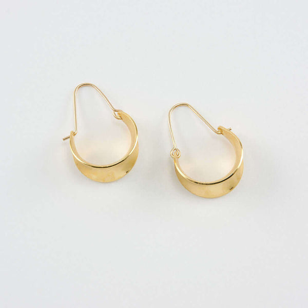 Pair of gold concave curved hoop earrings.