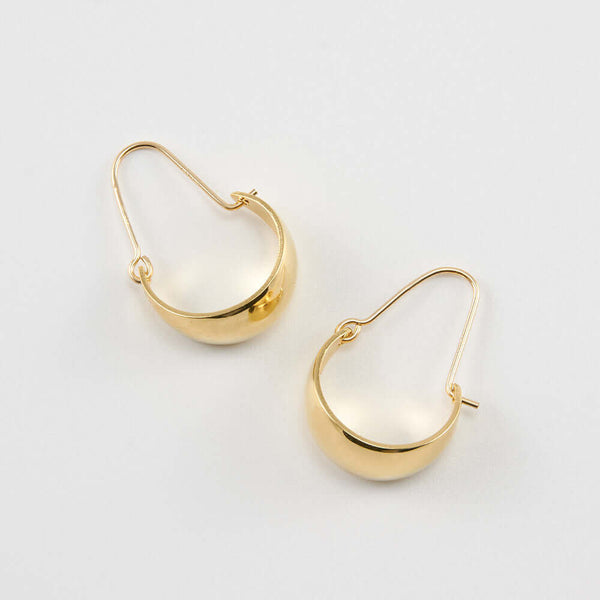 Pair of gold convex curved hoop earrings.