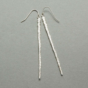 Pair of long silver earrings of thin cast feather on earwire.