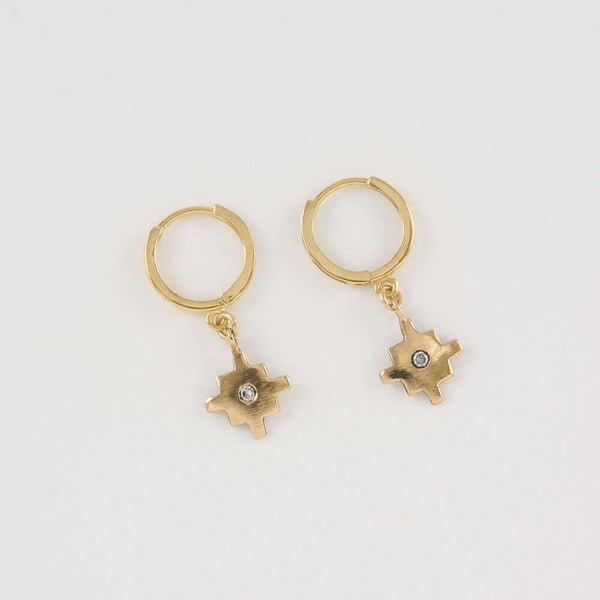 Pair of gold native motif cross earrings on hoop clasp.