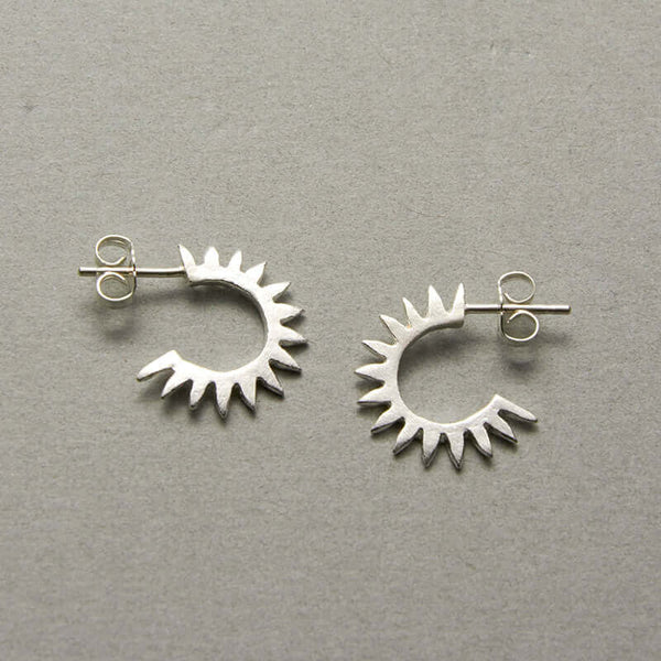 Pair of cast curved spiky silver earrings on posts.