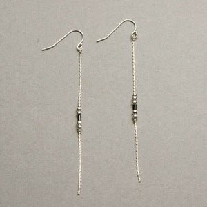 Pair of silver earrings, gold chain with black bead details.