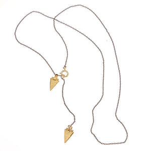 Black chain necklace with brass arrowheads, full length showing clasp.