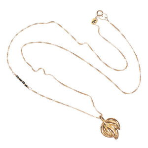 Gold chain with black bead accent on side, with pendant of bunch of curved pieces, full length showing clasp.