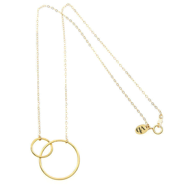 Delicate gold chain necklace with small and large interlocking circles as pendant, full length showing clasp.