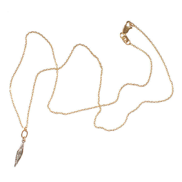 Delicate gold necklace with small elongated diamond shaped silver pendant with inset diamond.