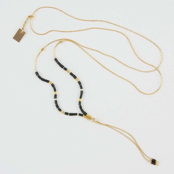 Delicate adjustable gold necklace with black and gold beads and gold rectangle drop pendant.