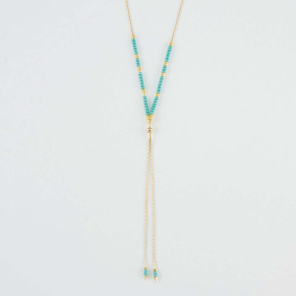 Close-up of delicate gold necklace with turquoise and gold beads shown reverse with adjuster bead.