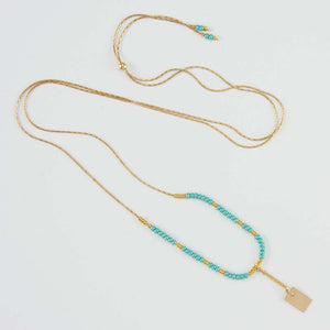 Delicate adjustable gold necklace with turquoise and gold beads and gold rectangle drop pendant.