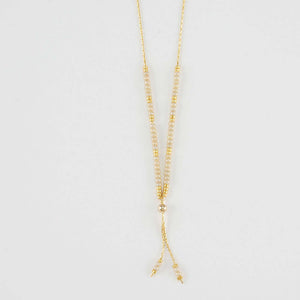 Close-up of delicate gold necklace with white and gold beads shown reverse with adjuster bead.