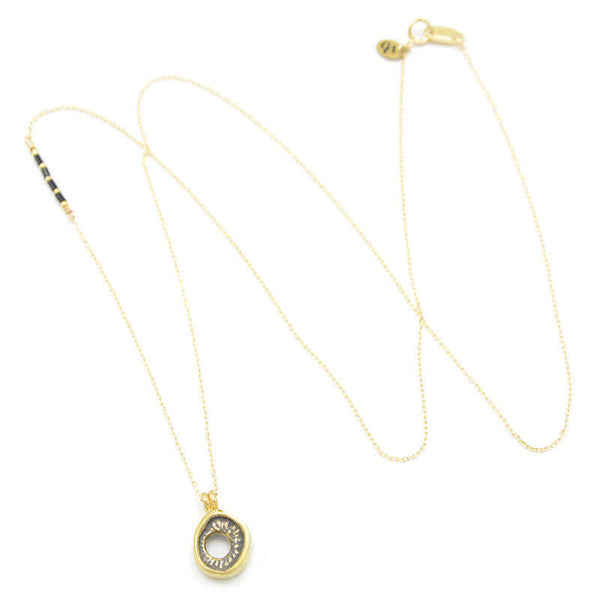 Delicate gold chain necklace with carved round pendant, shown full length.