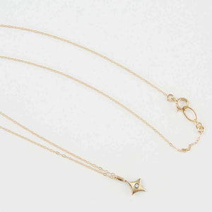 Delicate gold chain necklace with 4 point gold star pendant with inset diamond..