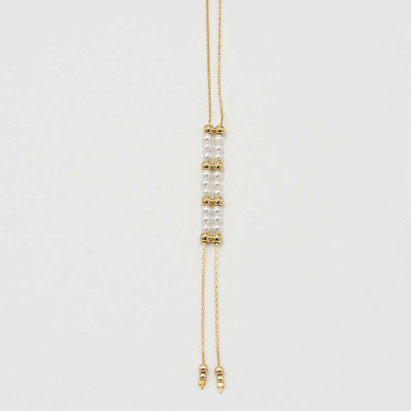 Close-up of gold chain necklace with pendant of double rows of white pearls and gold beads, that slide to adjust length.