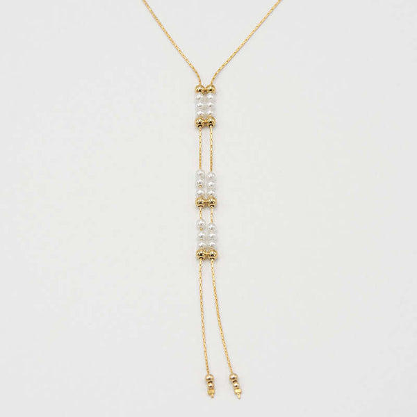 Close-up of gold chain necklace with pendant of double rows of white pearls and gold beads, that slide to adjust length.