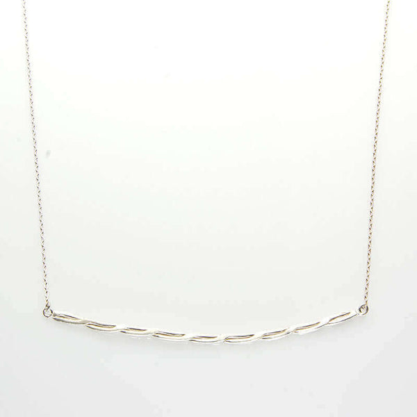 Close-up of silver chain necklace with cast twisted rope bar pendant.