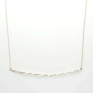 Close-up of silver chain necklace with cast twisted rope bar pendant.