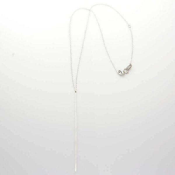 Silver chain necklace with long flattened wire pendant.