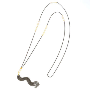 Black oxidized silver necklace with black tassel pendant and oval gold link details on chain.