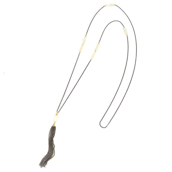 Black oxidized silver necklace with black tassel pendant and oval gold link details on chain.