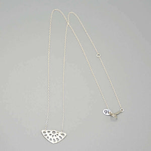 Delicate silver chain necklace with lotus root motif pendant.