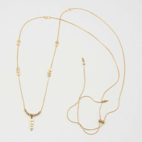 Delicate gold chain necklace with pendant of round beads with flat bead drop.