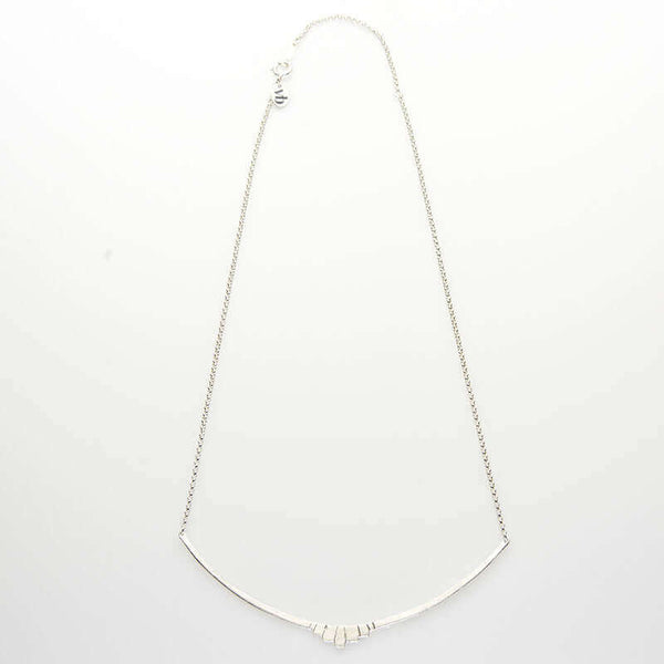 Silver necklace with curved bar pendant with geometric native motif.