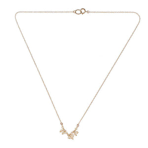 Delicate gold necklace with small pearls as pendant.