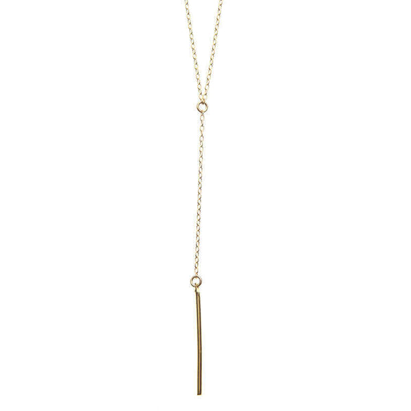Close-up of dainty gold necklace with pendant of simple drop chain and bar.