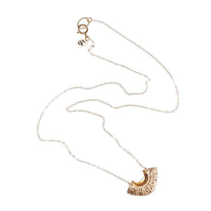Dainty gold necklace with fan shaped pendant.