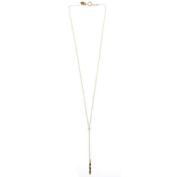 Dainty gold necklace with pendant of simple drop chain and black beads.
