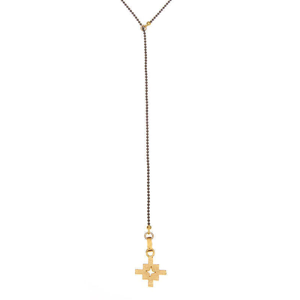 Close-up of dark bead chain necklace with small geometric cross shaped pendant and slider.