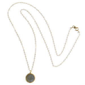Long gold chain necklace with etched coin shaped pendant.