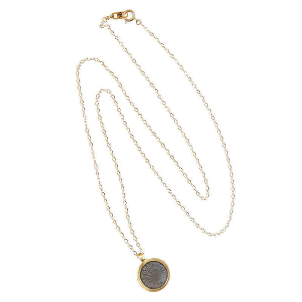 Long gold chain necklace with etched coin shaped pendant.