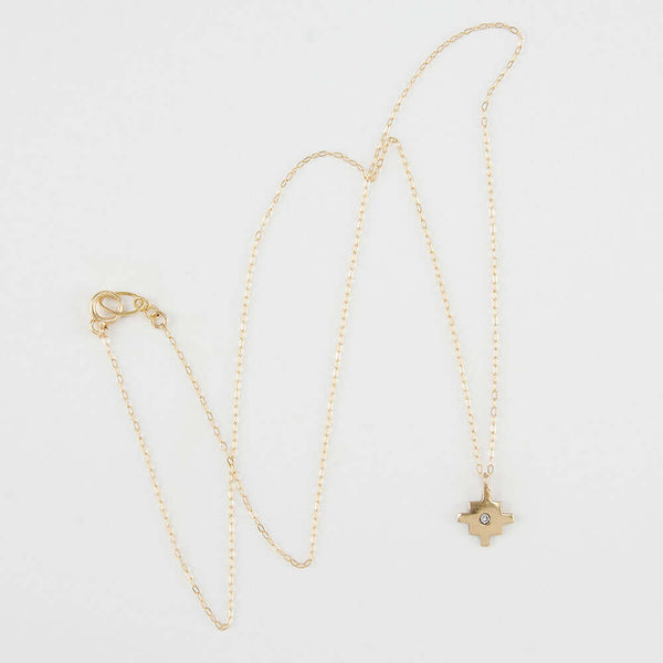 Delicate gold chain necklace with gold native motif cross pendant with inset diamond.